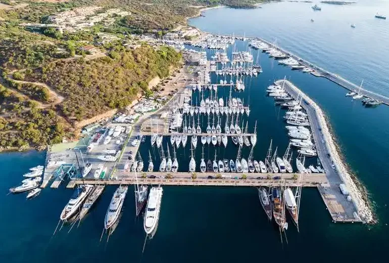 Aerial of Marina di Portisco pontoons crowded with sailing yachts and superyachts