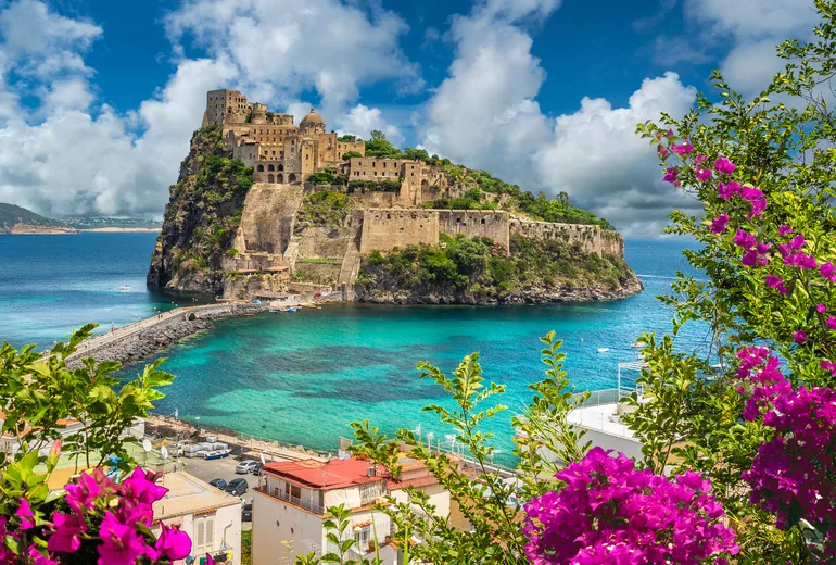Aragonese Castle islet framed by pink bougainvillea on Ischia island