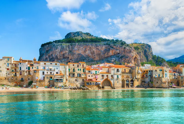 Cefalu old town houses on the shore beneath the La Rocca crag, Sicily