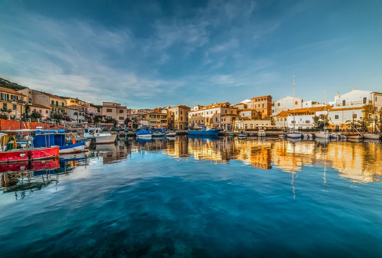 Fishing boats and golden reflections in La Maddalena town harbour, Sardinia