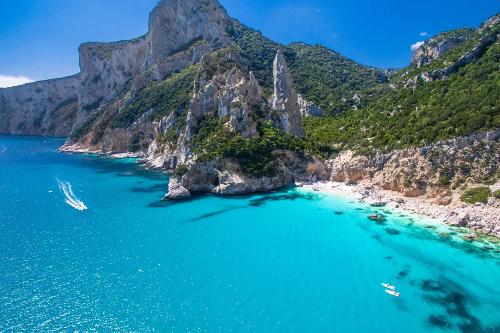 Aerial of Cala Goloritze cove with limestone pinnacle and turquoise water, Sardinia