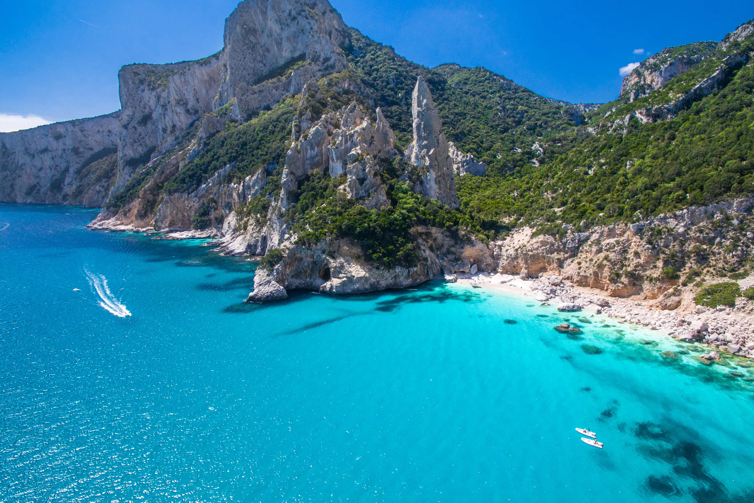 Aerial of Cala Goloritze cove with limestone pinnacle and turquoise water, Sardinia