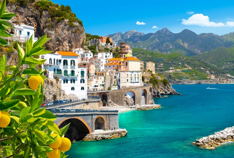 Lemon tree framing Atrani village and the arched coastal road on the Amalfi Coast