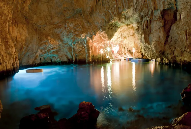 Rowboat inside the glowing Emerald Grotto sea cave at Conca dei Marini