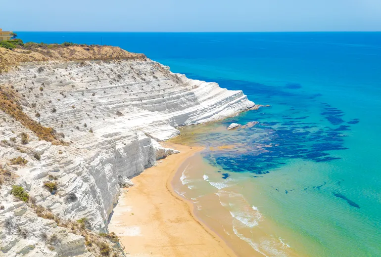 The white marl cliffs of Scala dei Turchi above a golden beach, Sicily